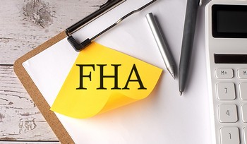First-time homebuyer reviewing FHA loan documents with a low down payment calculator